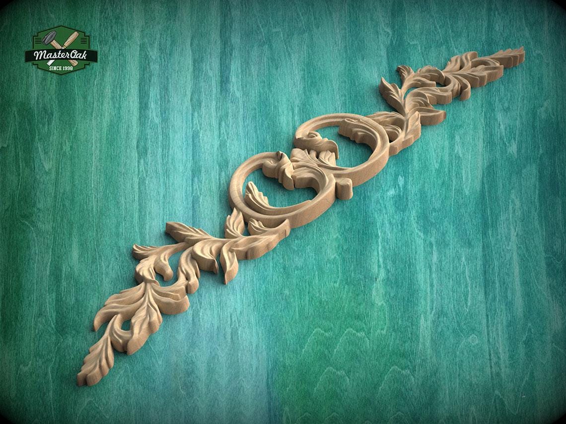 A decorative wooden carving with intricate floral patterns is displayed against a green background.