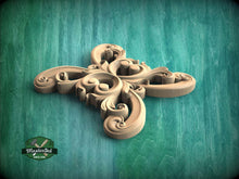 Load image into Gallery viewer, A decorative wooden carving in the shape of a flower or flower-like design, with intricate swirls and curves, is displayed against a green background.
