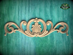 a decorative wooden carving on a green background.