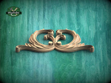 Load image into Gallery viewer, A decorative wooden ornament with an intricate, swirling design is displayed against a textured green background.
