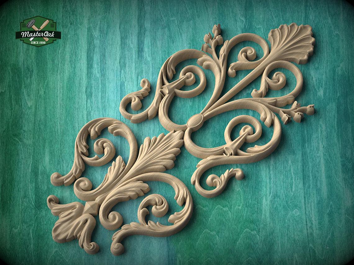 a decorative wooden carving with intricate scrollwork and floral elements, set against a teal background.