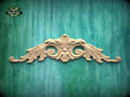 a decorative wooden carving on a green wooden surface.