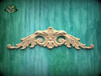 a decorative wooden carving on a green wooden surface.