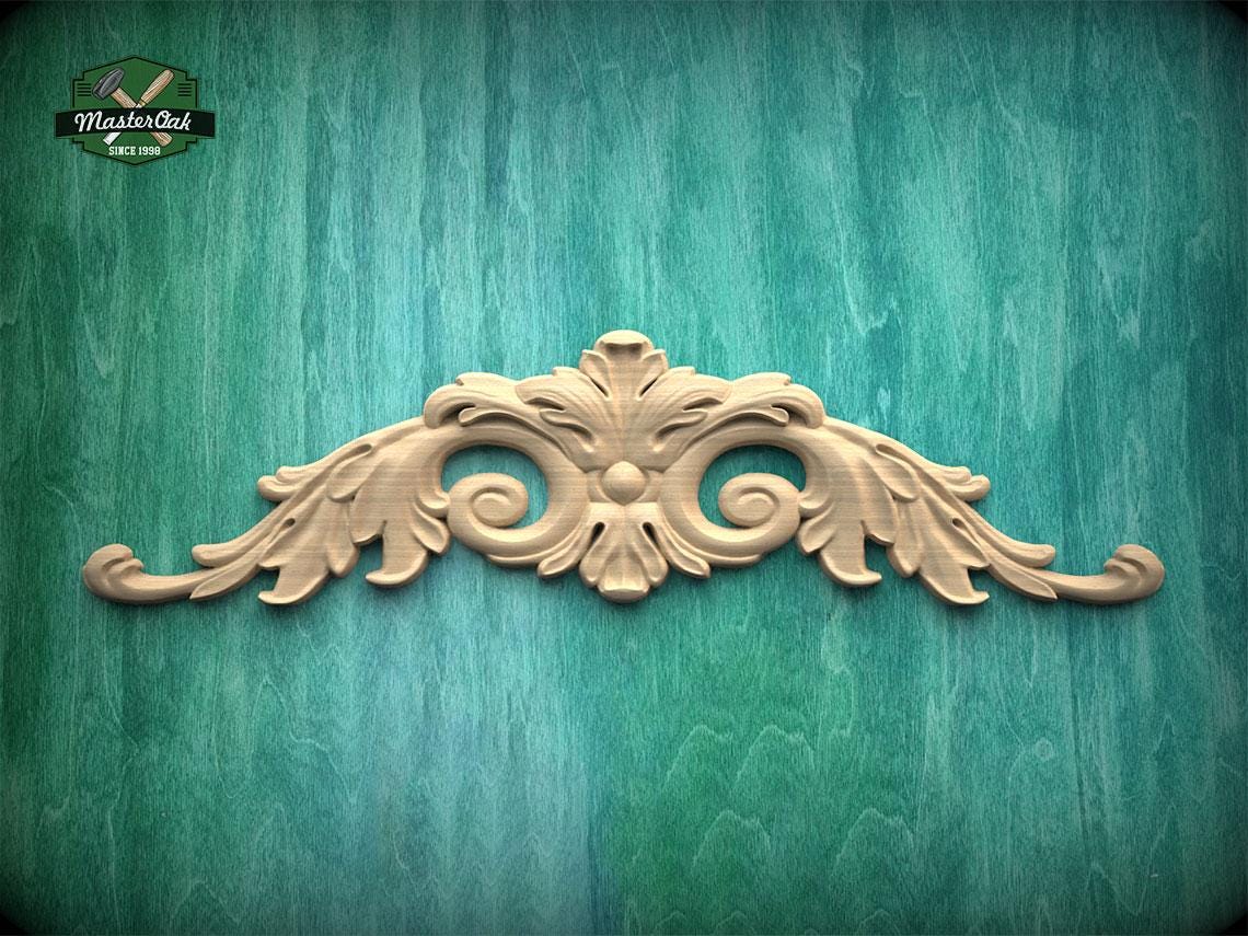 a decorative wooden carving on a green wooden surface.