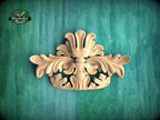 a decorative wooden carving on a green background.