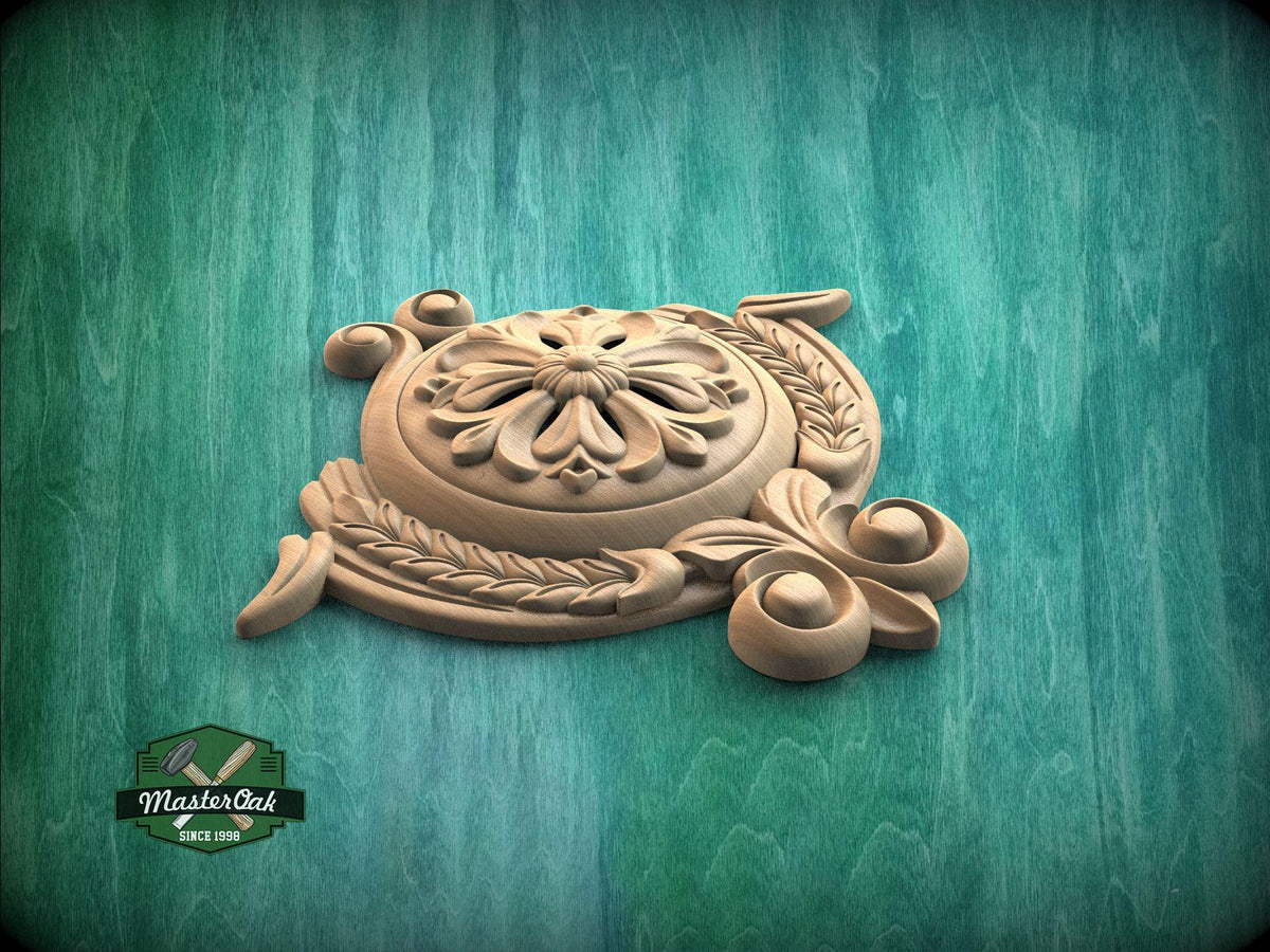 A wooden carving with intricate floral and leaf designs sits on a green wooden surface.