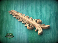 Load image into Gallery viewer, A decorative wooden leaf-like object with intricate curves and patterns, resting on a green textured background.

