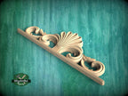 A decorative wooden carving with an intricate, ornate design is displayed against a teal-colored background.