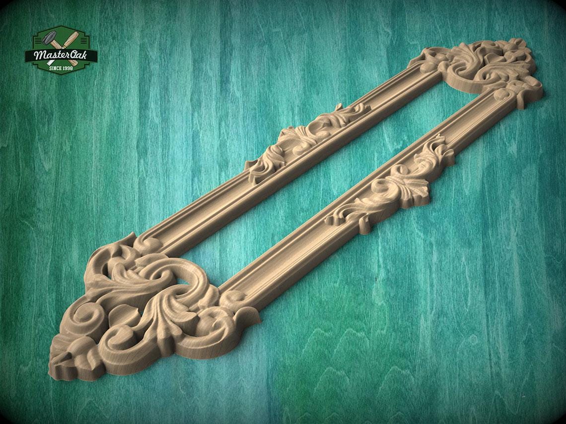 A decorative wooden frame with intricate carvings and patterns, displayed against a green wooden background.