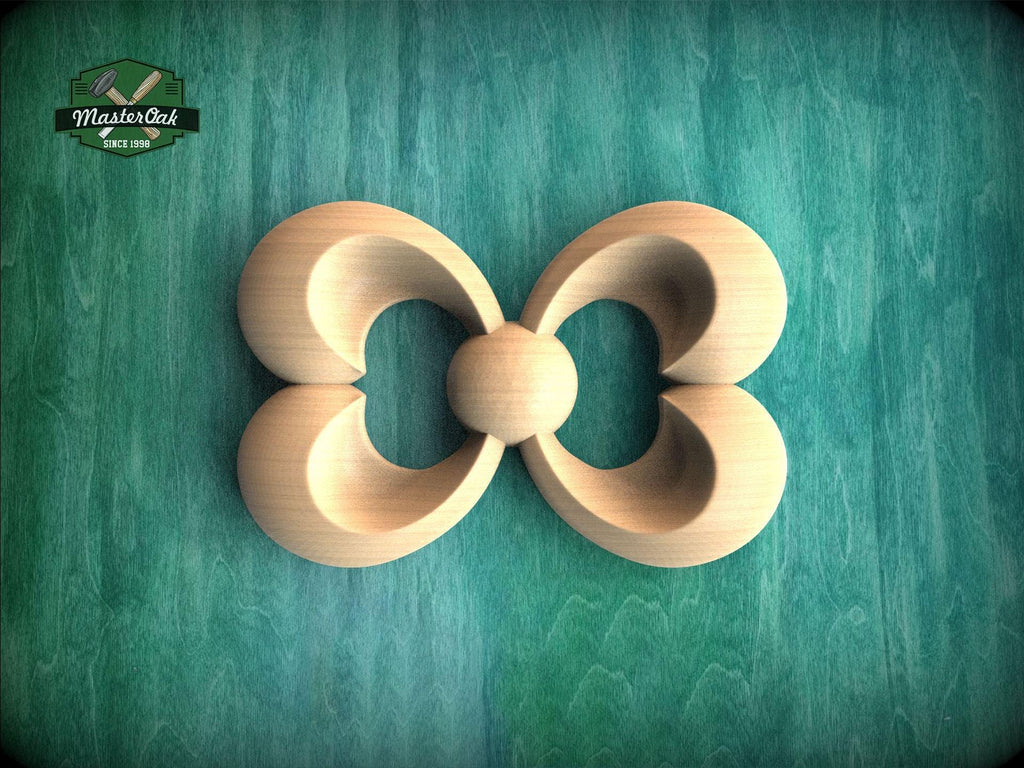 A wooden carving of a stylized flower or butterfly shape is displayed against a green background.