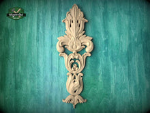 Load image into Gallery viewer, a decorative wooden carving on a teal-colored background.
