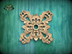 a decorative wooden piece with an intricate, symmetrical design on a green background.