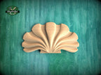 A wooden shell-shaped object is displayed against a green background.