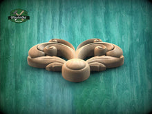 Load image into Gallery viewer, A wooden carving of a stylized flower or leaf design is displayed against a green background.
