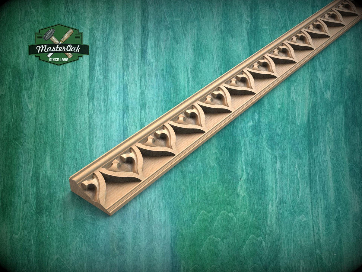 Carved wooden gothic molding with repeating arch and floral pattern, used as decorative trim for cabinets, furniture or wall panels.