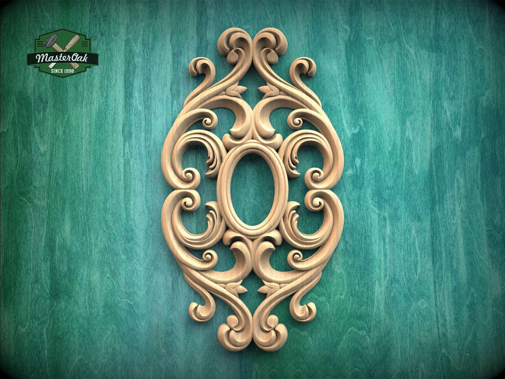 an ornate, carved wooden piece with an oval shape and intricate scrollwork, set against a green background.