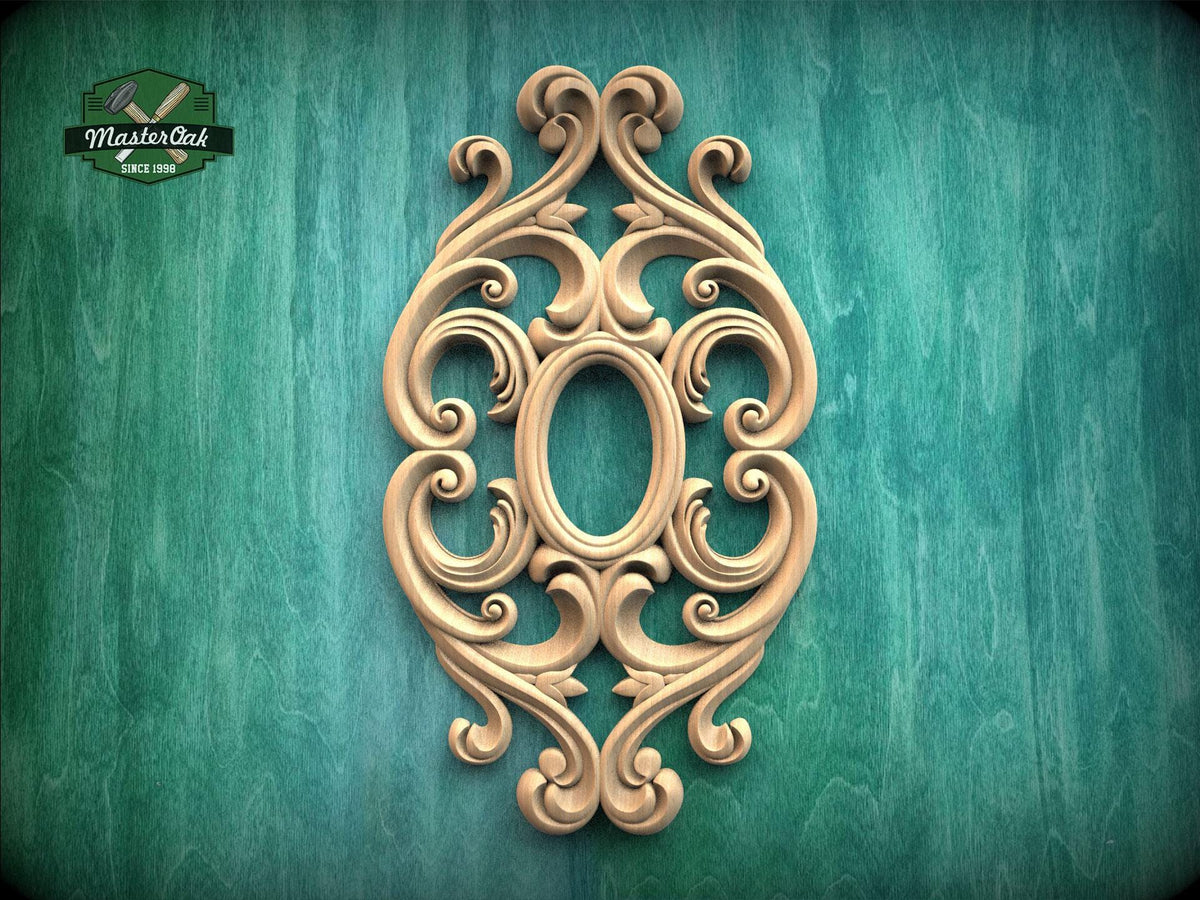 an ornate, carved wooden piece with an oval shape and intricate scrollwork, set against a green background.