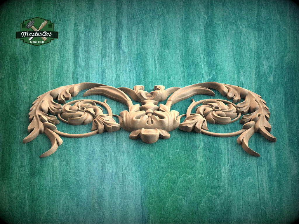 A decorative wooden carving with intricate floral and leaf-like patterns is displayed against a green wooden background.