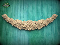 A decorative wooden piece with a floral design, featuring numerous light brown wooden roses arranged in a curved pattern against a teal-colored background.
