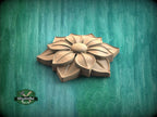 A wooden flower-shaped object is displayed against a green background.
