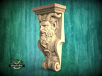 A carved wooden sculpture of a bearded man with horns, displayed against a green background.