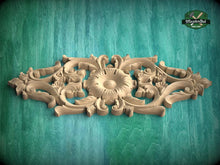 Load image into Gallery viewer, A carved wooden design with intricate floral and scrollwork patterns is displayed against a green textured background.
