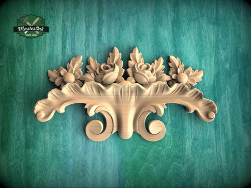 a decorative wooden carving of a floral design on a green background.
