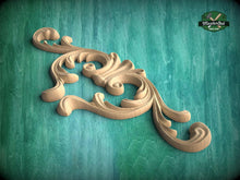 Load image into Gallery viewer, A wooden carving with an intricate, swirling design is displayed against a teal background.
