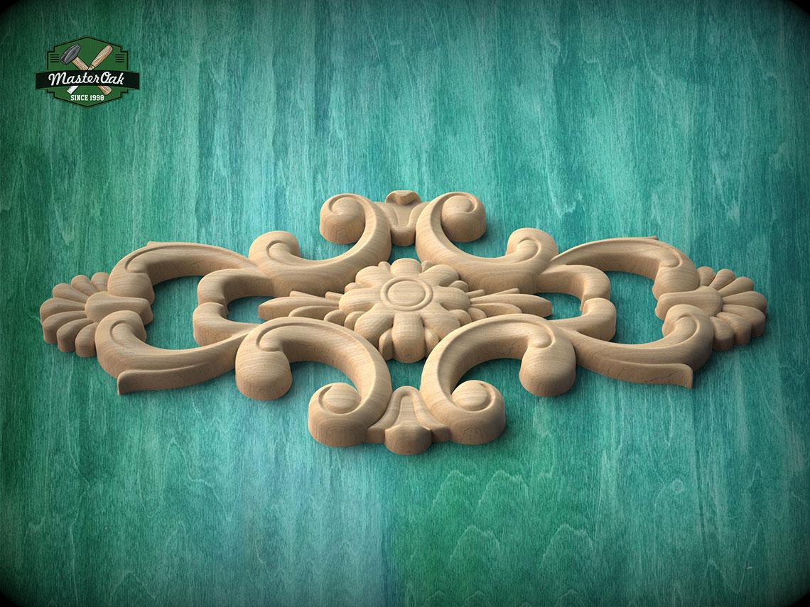 A decorative wooden carving with intricate floral and scrollwork designs is displayed against a green wooden background.