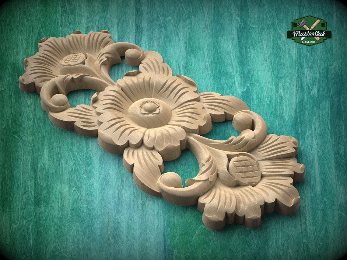 A wooden carving of a flower with intricate details, displayed on a green wooden surface.