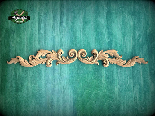 A decorative wooden carving with intricate scrollwork is displayed against a textured green background.