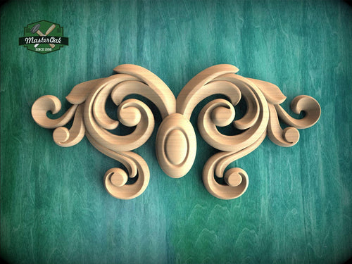 a wooden carving of two swirls on a green surface