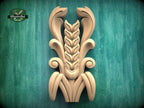 a carved wooden design with a stylized wheat stalk and leaves, set against a green background.