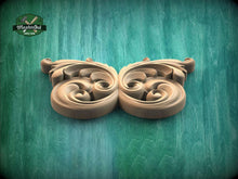 Load image into Gallery viewer, A decorative wooden carving with intricate scrollwork is displayed against a green background.
