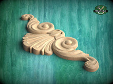 Load image into Gallery viewer, A carved wooden ornament with a swirling, organic design is displayed against a green background.
