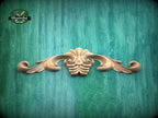 a wooden carving of a flower on a green background