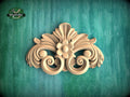 a decorative wooden carving on a green background.