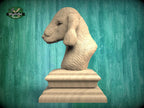 A wooden bust of a dog's head is displayed on a wooden pedestal against a green background.