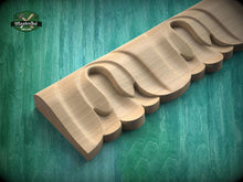 Load image into Gallery viewer, A wooden carving with a curved, organic shape is displayed against a green background.
