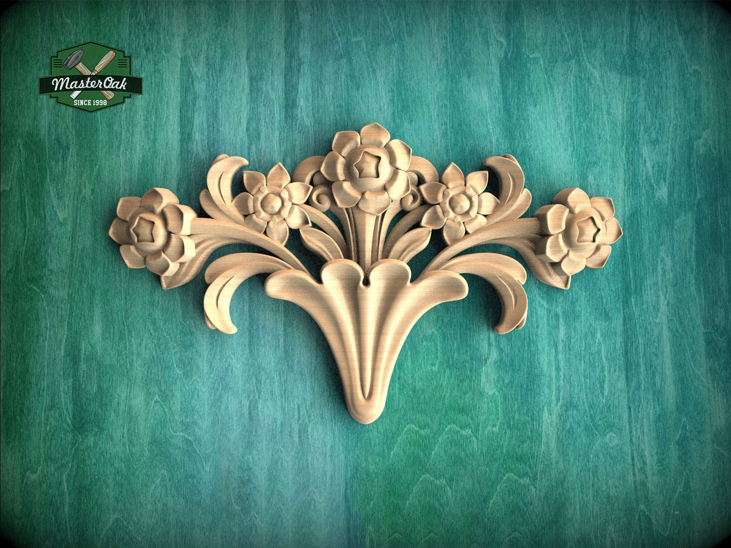A decorative wooden carving of a flower on a green background.