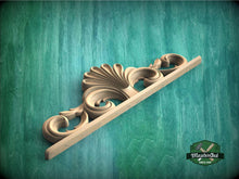 Load image into Gallery viewer, A decorative wooden carving with a floral design is displayed against a green textured background.
