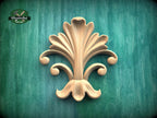 a decorative wooden leaf-like design on a green background.