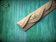 Load image into Gallery viewer, A wooden carving with a rose design is displayed against a green background.
