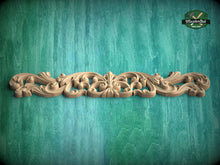Load image into Gallery viewer, A decorative wooden carving with intricate scrollwork is displayed against a green textured background.
