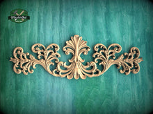 Load image into Gallery viewer, an ornate, carved wooden design with intricate scrollwork and floral patterns, set against a green textured background.
