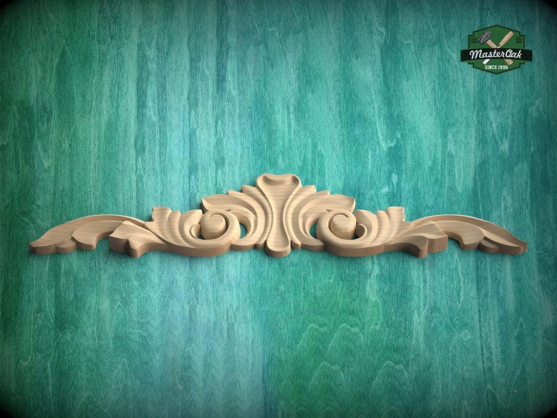 A decorative wooden carving is displayed against a teal-colored background.
