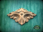 A decorative wooden piece with an intricate, organic design is displayed against a green background.