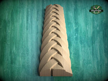 Load image into Gallery viewer, A wooden carving of a braided pattern is displayed against a green background.
