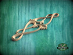 A wooden carving with an intricate design is displayed against a green textured background.
