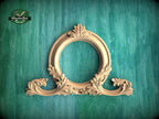 an ornate wooden frame with intricate carvings, set against a green textured background.
